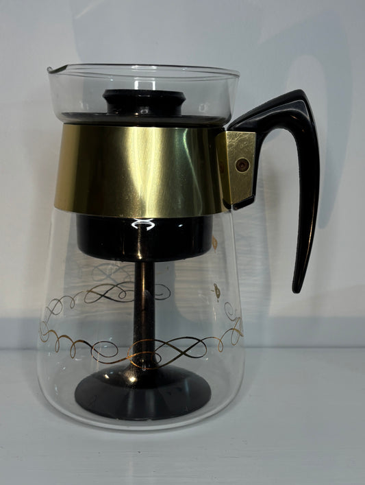 Clear glass coffee maker with black handle and base on a white background