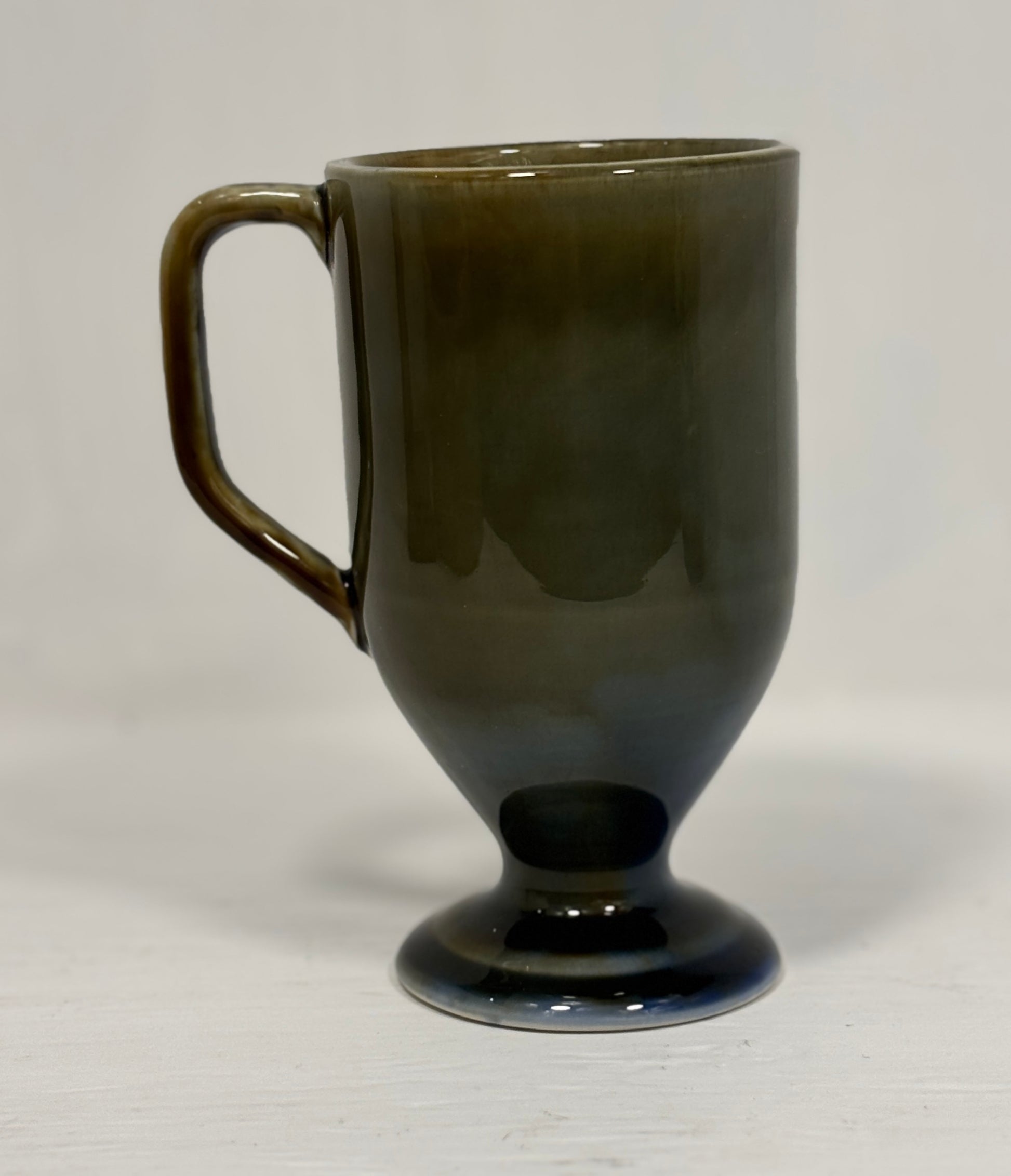 Dark green ceramic mug on a light gray background