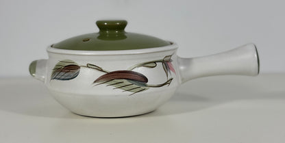 Ceramic pot with a lid and handle on a white background