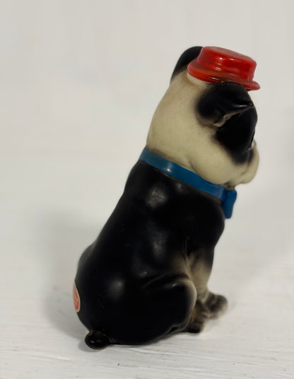 Dog figurine with a red hat and blue collar on a white background