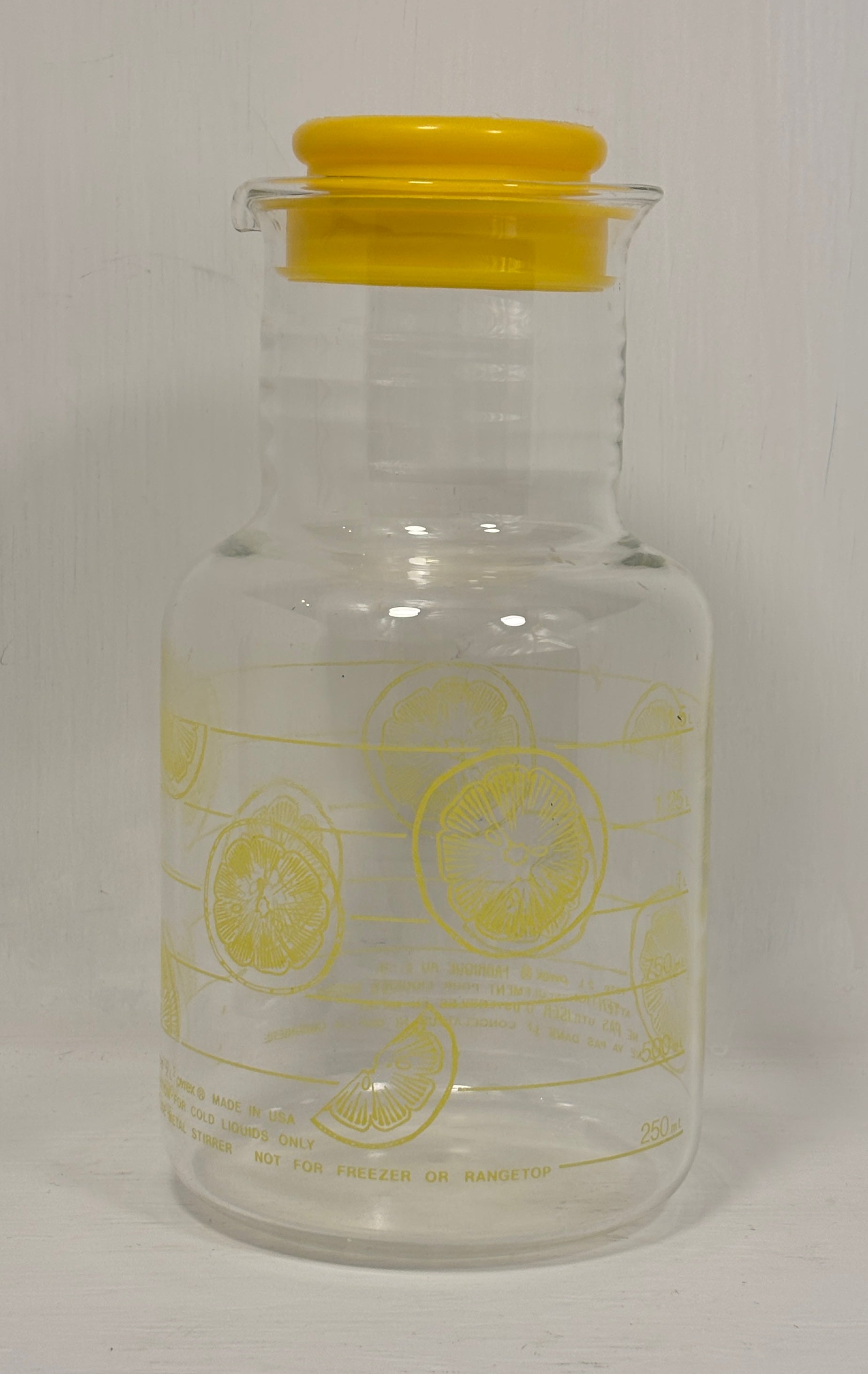 Clear glass jar with yellow lid and lemon illustrations on a white background