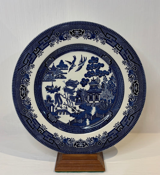 Blue and white decorative plate with intricate patterns on a stand against a white background
