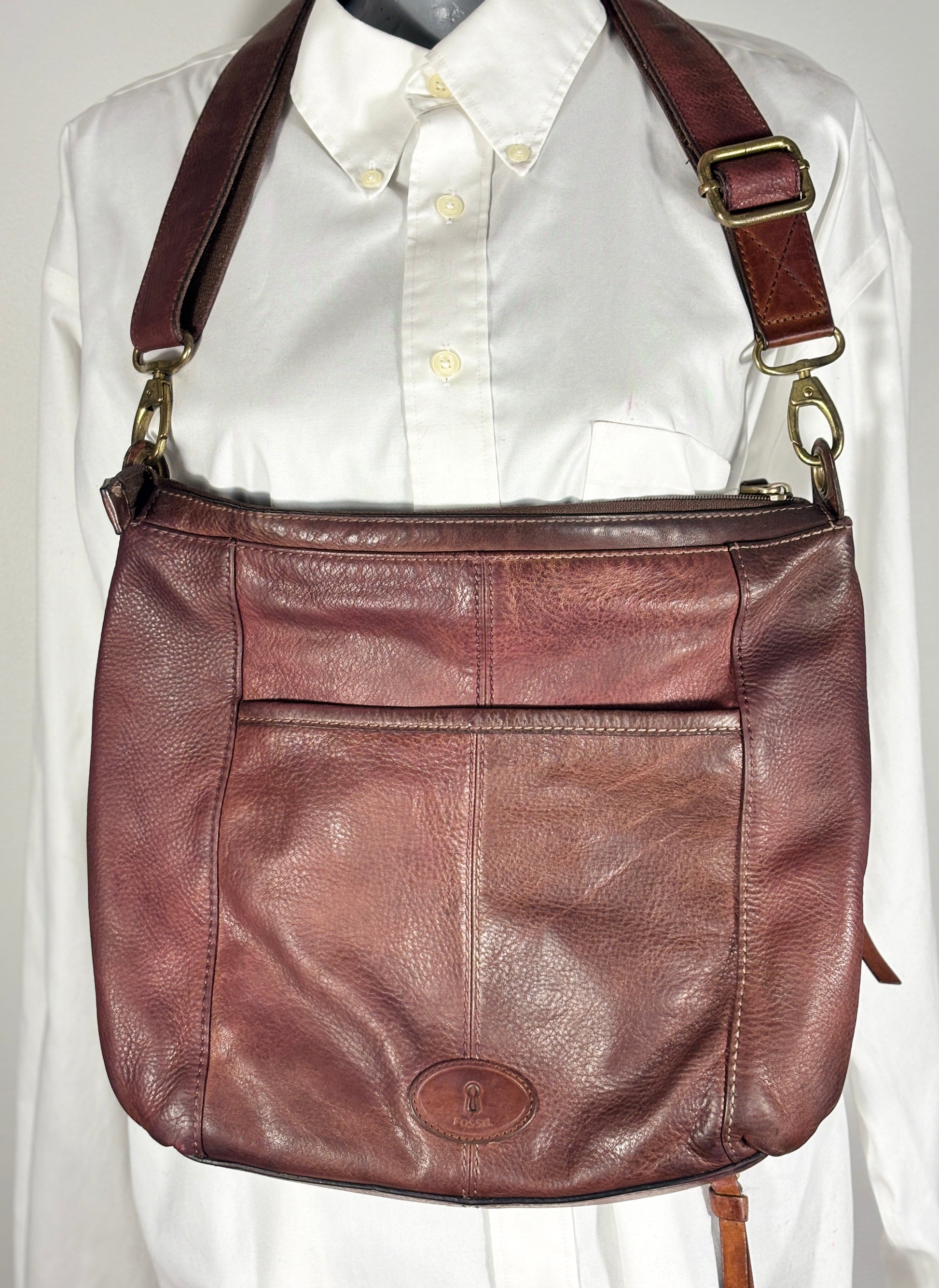 Brown leather shoulder bag on a white shirt