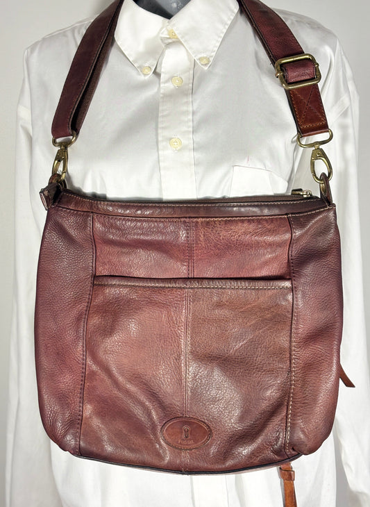 Brown leather shoulder bag on a white shirt