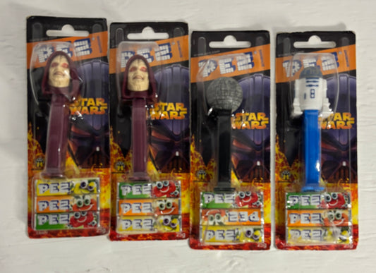 Four Star Wars-themed PEZ dispensers in packaging on a white background