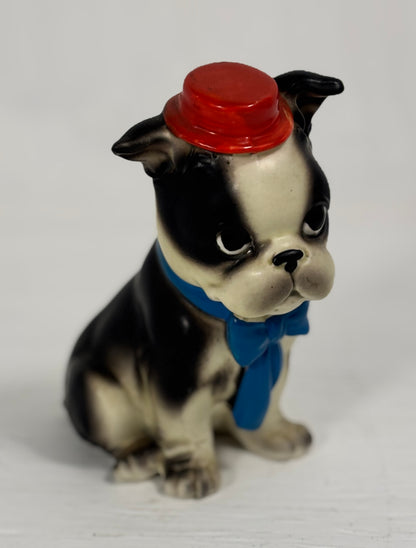 Dog figurine with a red hat and blue scarf on a white background