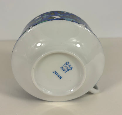 Ceramic mug with a colorful design on the handle, brand name visible on the base.