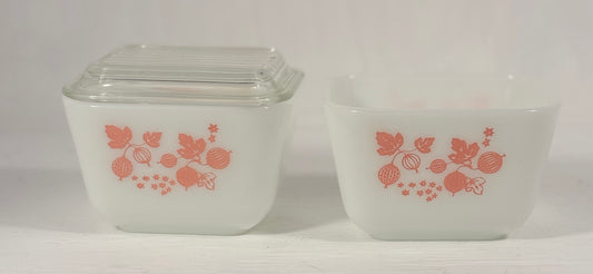 Two vintage glass containers with pink floral design on a white background