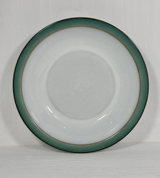 White ceramic plate with a green rim on a white background
