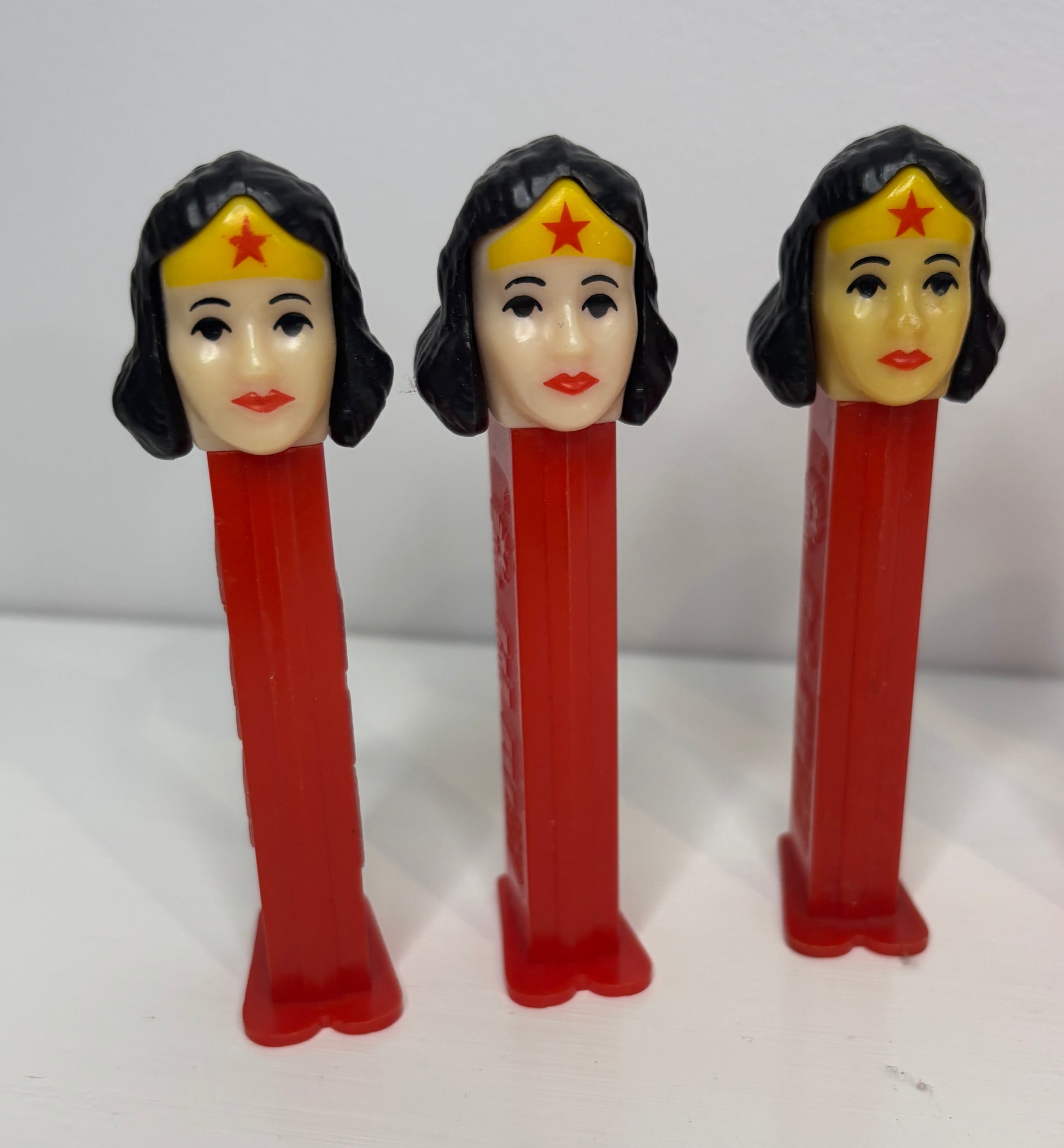 Three Wonder Woman-themed PEZ dispensers on a white background