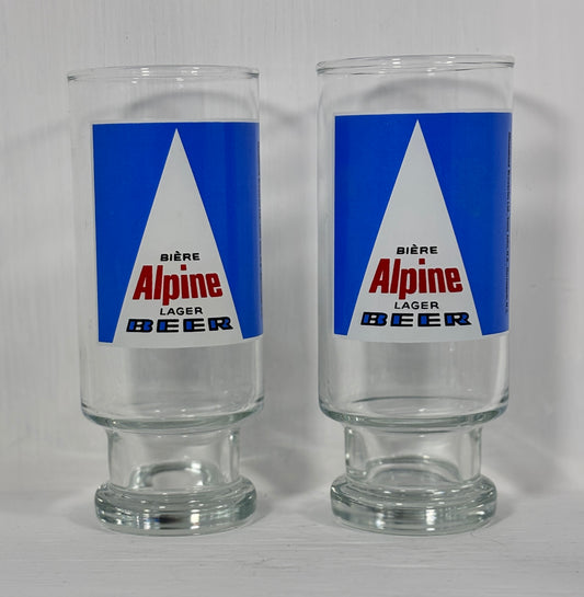 Two glass tumblers with Alpine Lager Beer label on a white background