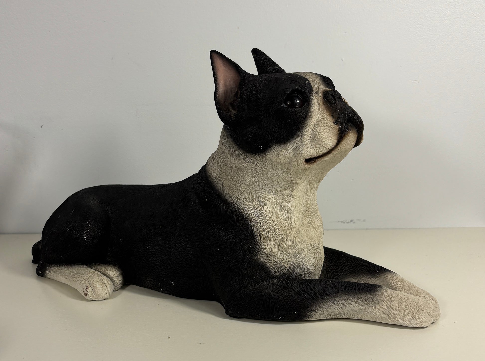 Black and white dog figurine on a plain background