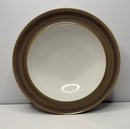 Round ceramic dish with brown rim on a white background