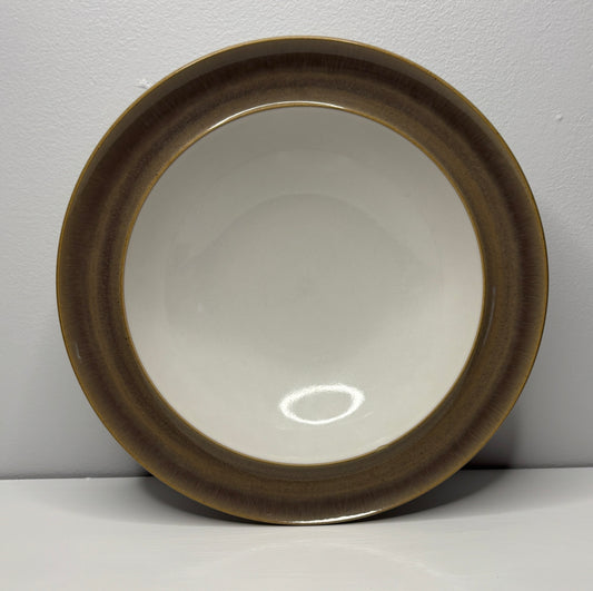 Round ceramic dish with brown rim on a white background