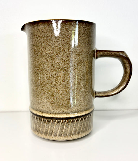 Stoneware mug with textured surface and handle on a white background