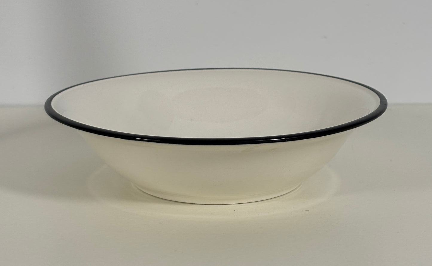 White bowl with black rim on a white background