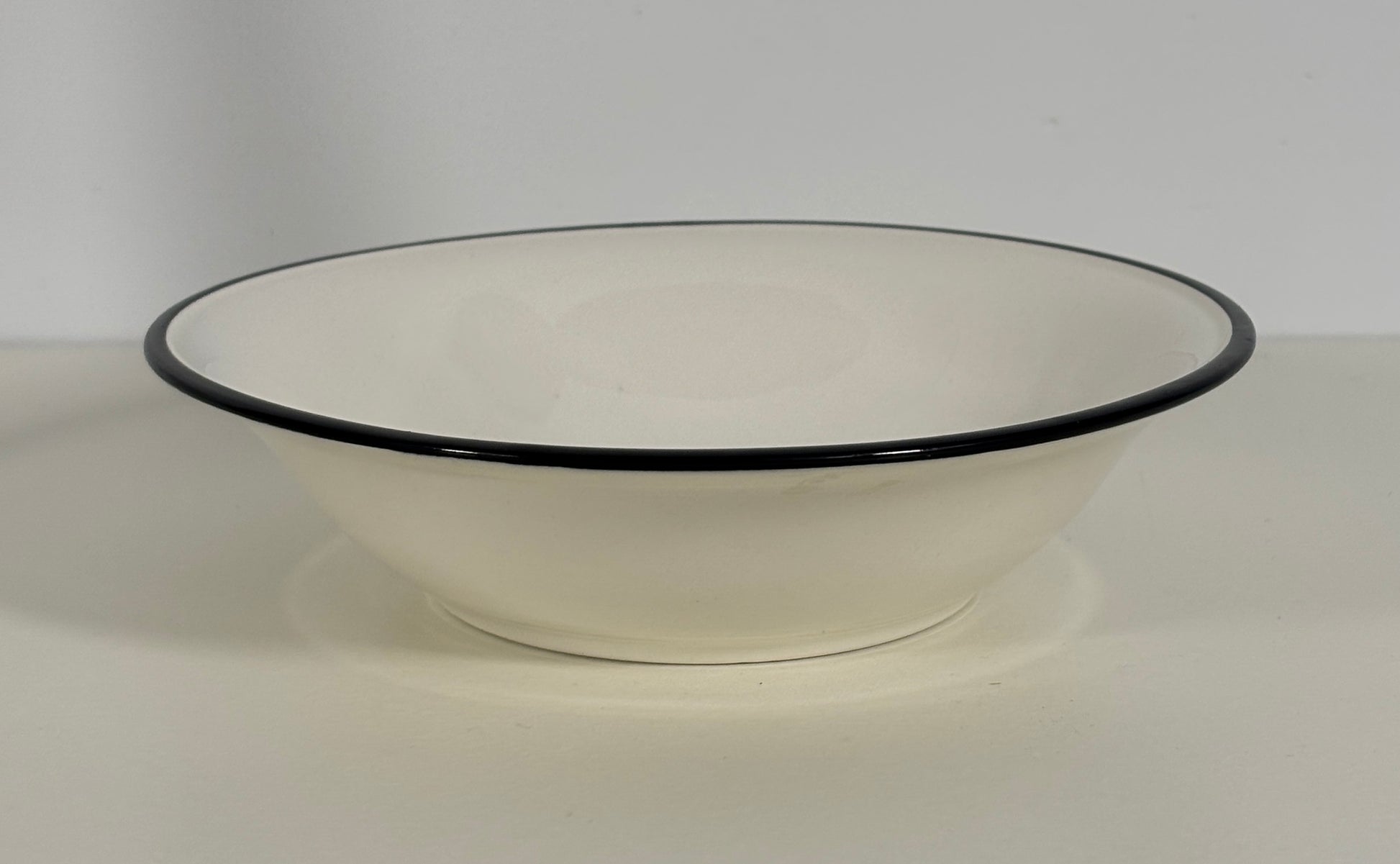 White bowl with black rim on a white background