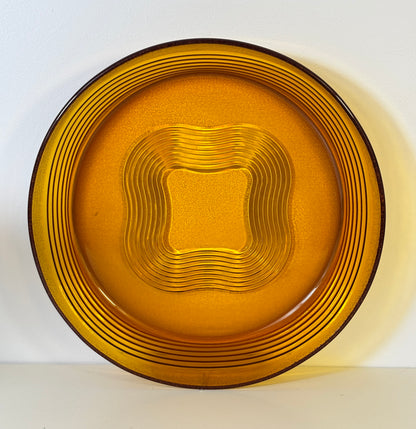Gold-colored glass plate with concentric circle pattern on a white background