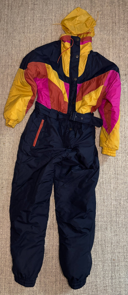 Colorful snowsuit with a yellow hood on a textured surface