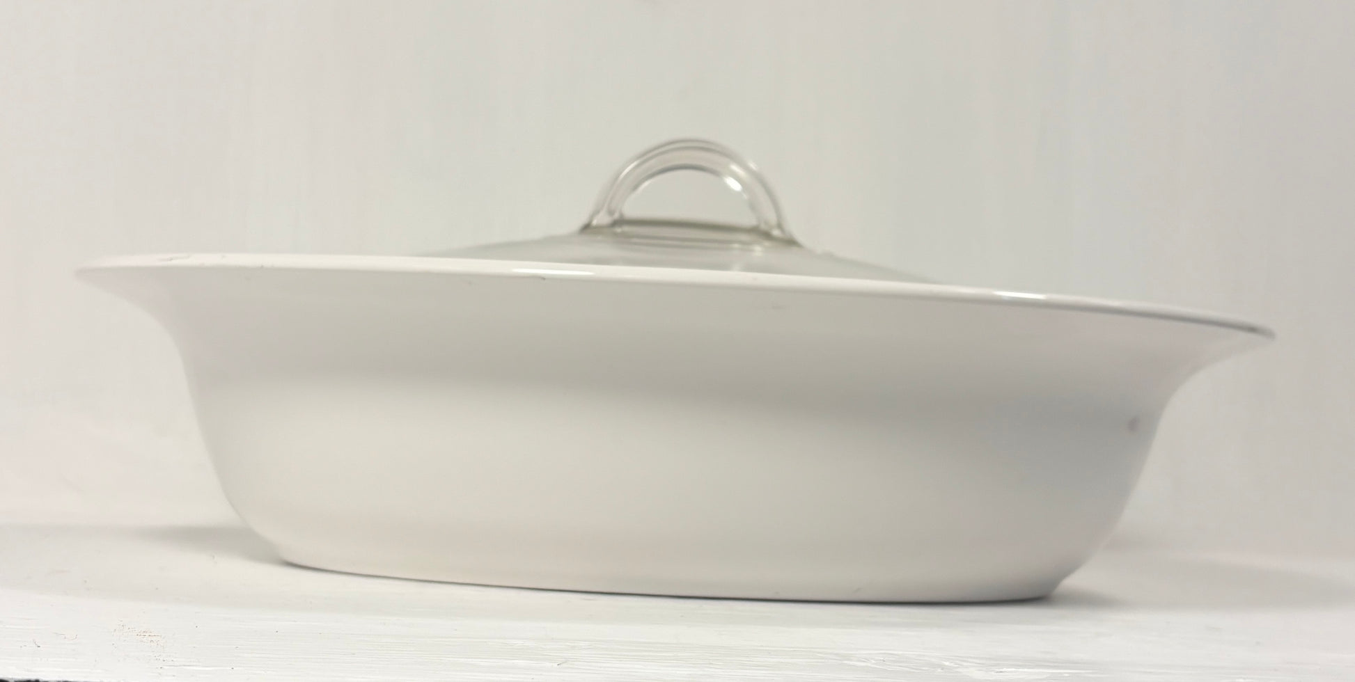 White ceramic dish with a lid on a white background