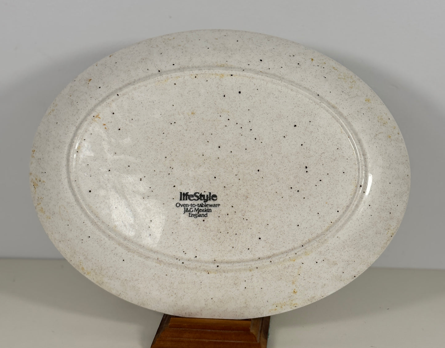 Speckled ceramic plate with 'lifestyle' branding on a plain background