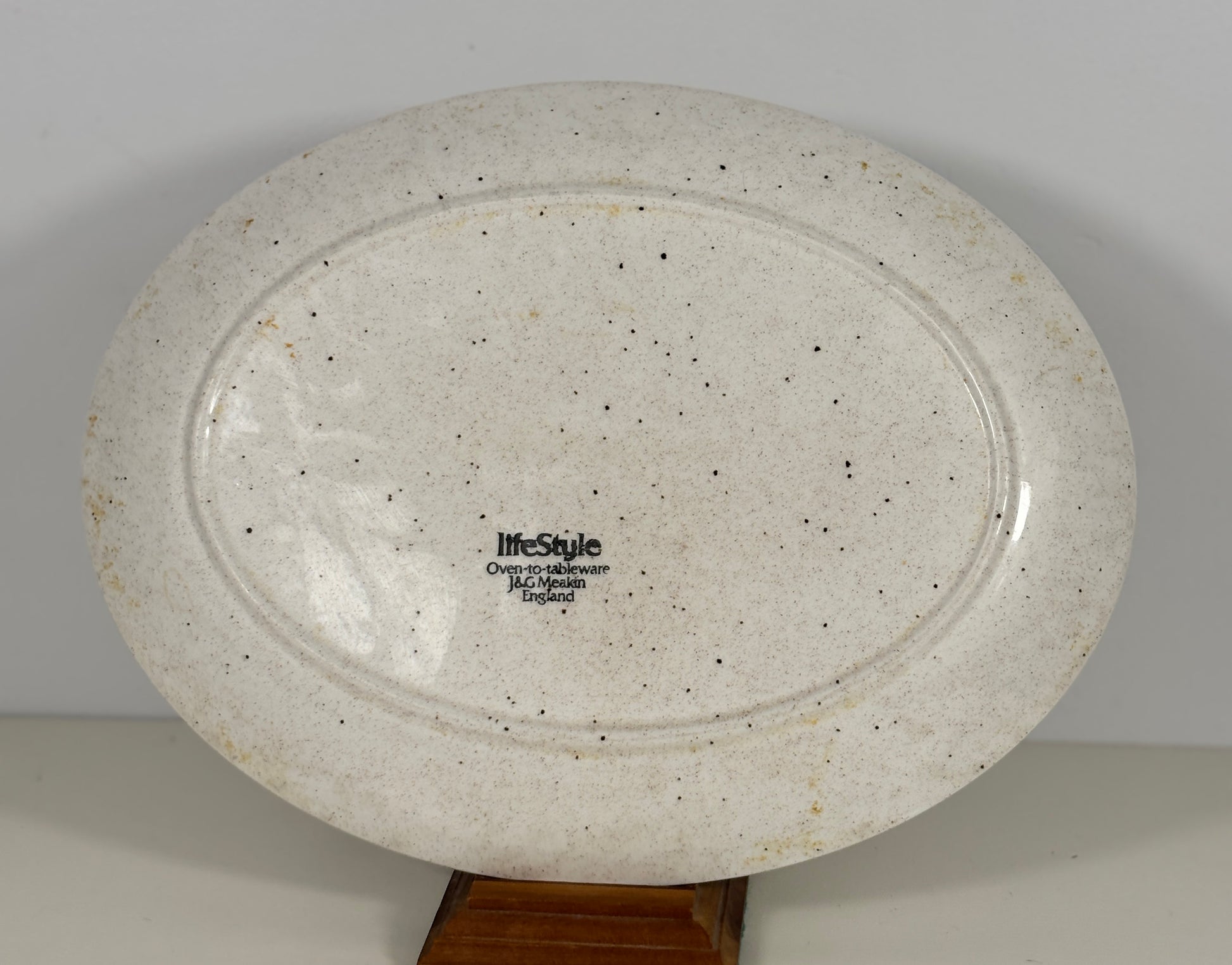 Speckled ceramic plate with 'lifestyle' branding on a plain background