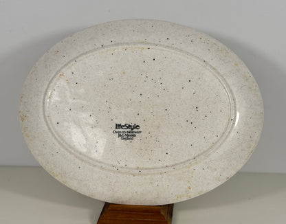 Speckled ceramic plate with 'lifestyle' branding on a plain background