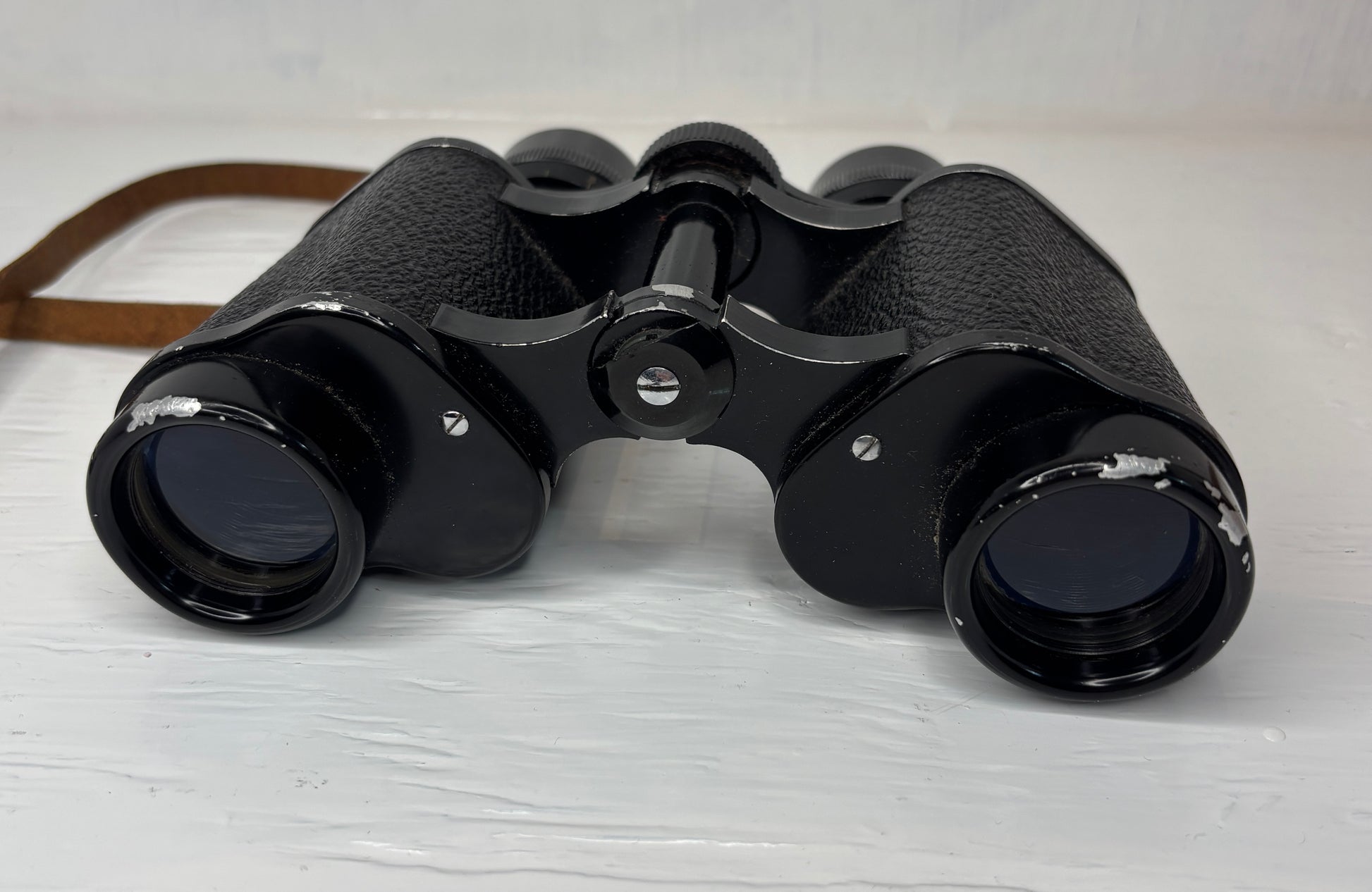 Black binoculars on a light wooden surface