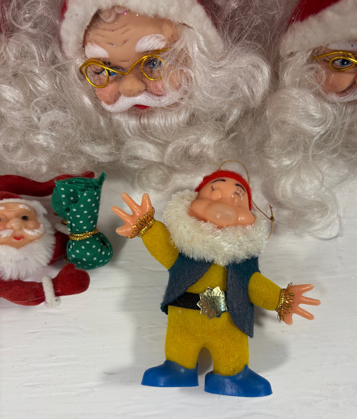 Close-up of a Santa Claus figure and a dwarf figurine on a white background