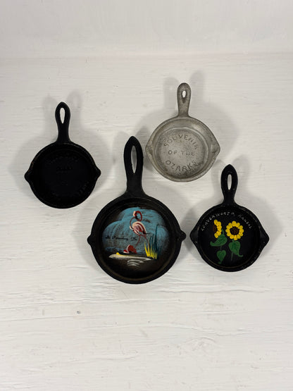 Set of decorative mini skillets with artistic designs on a white background