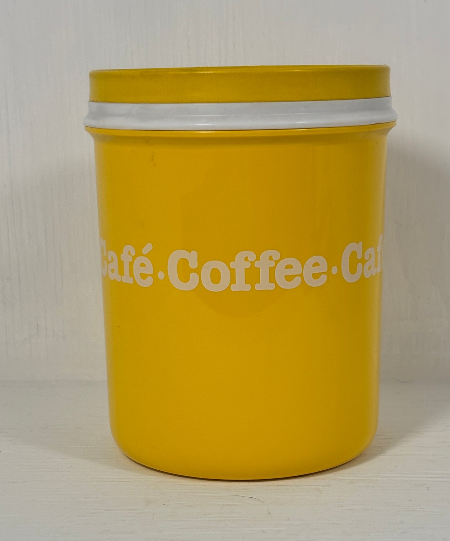 Yellow coffee canister with white text on a light background