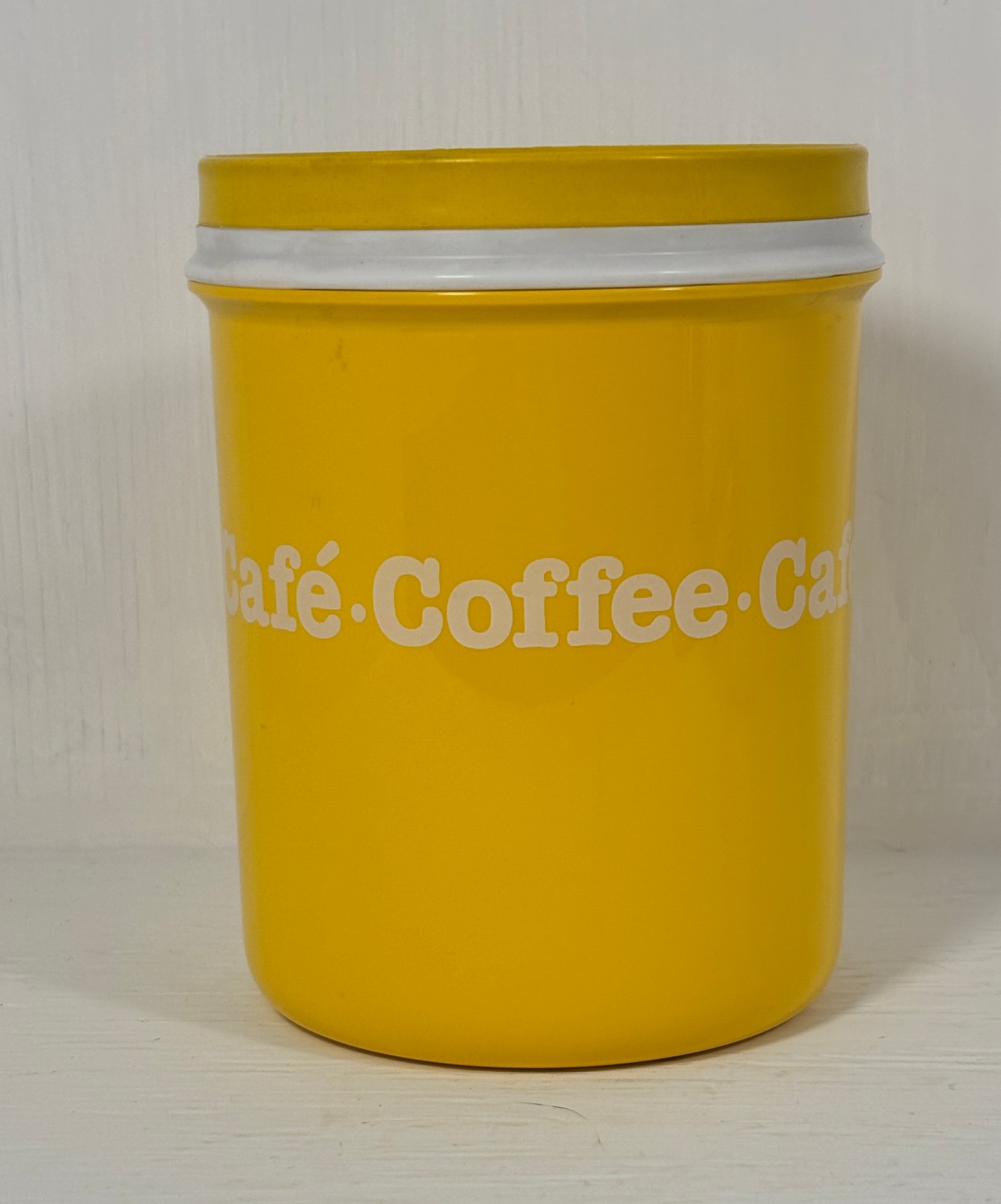 Yellow coffee canister with white text on a light background