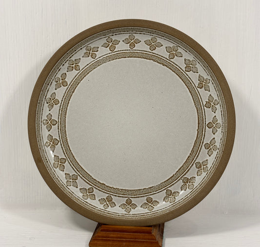 Decorative plate with floral patterns on a stand against a white background