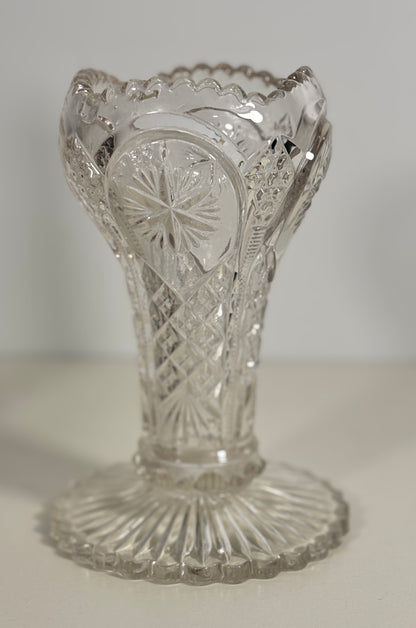 Clear glass vase with intricate cut patterns on a white background