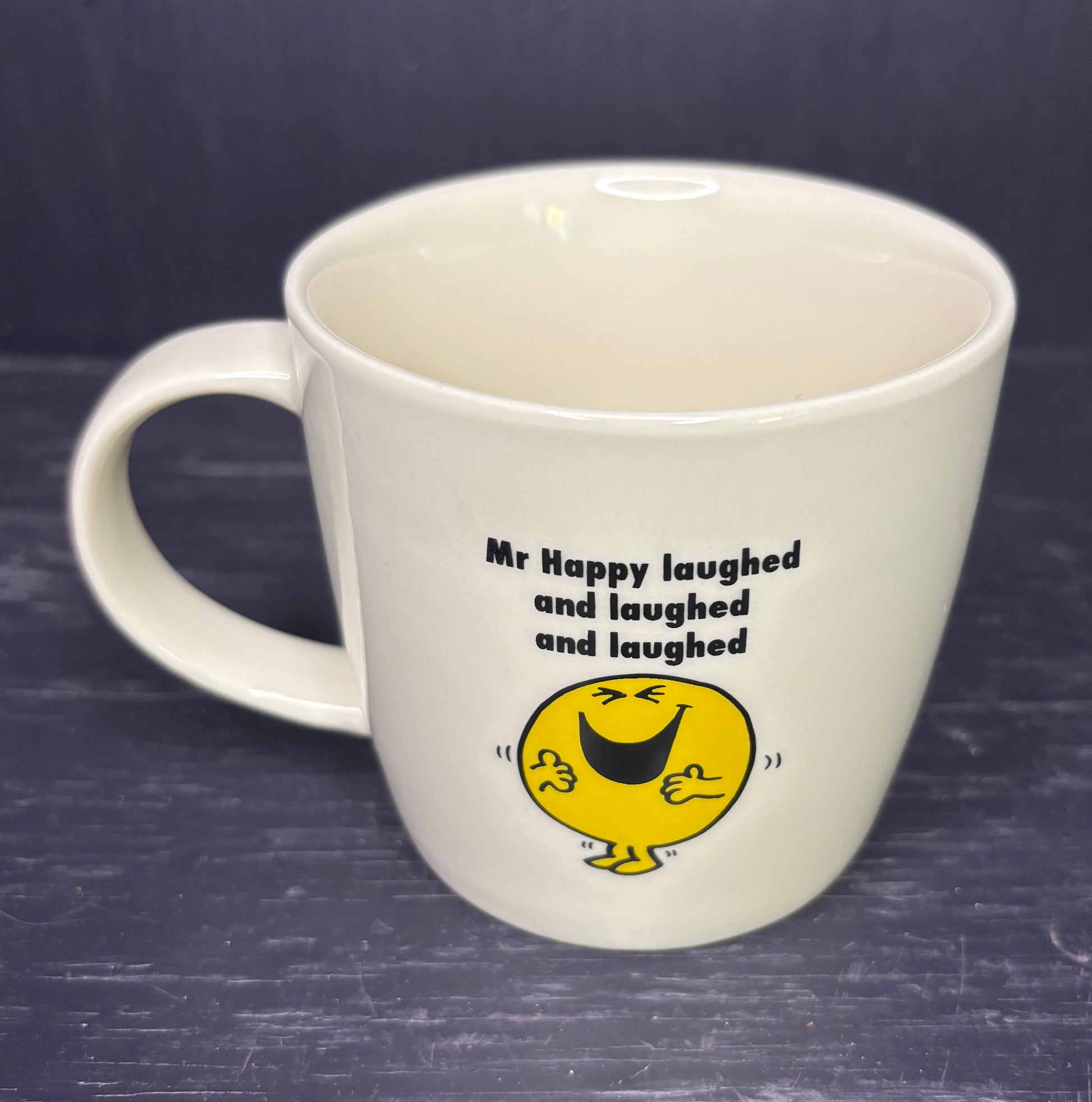 White mug with a yellow character and text on a dark background
