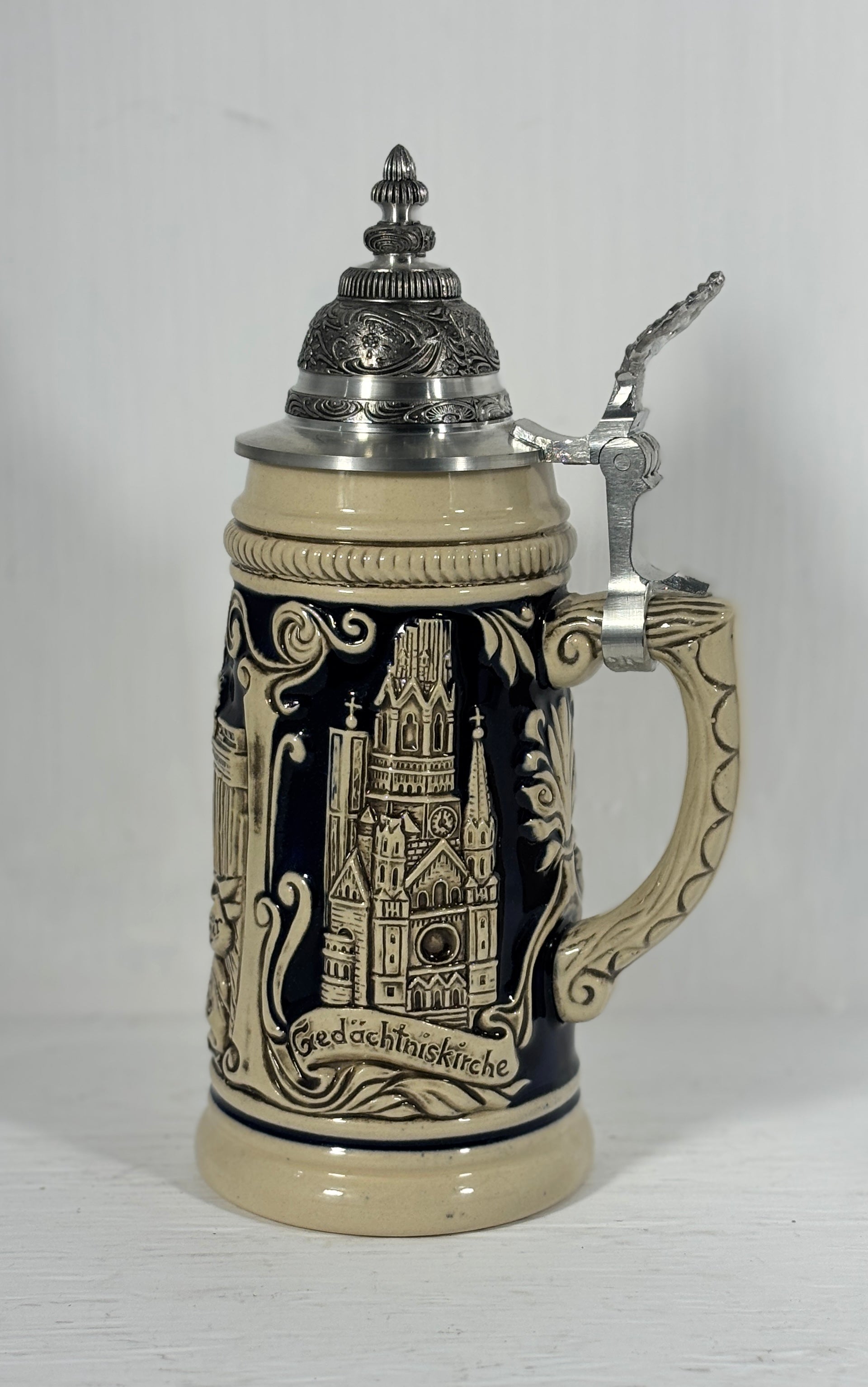 Decorative beer stein with architectural design on a white background