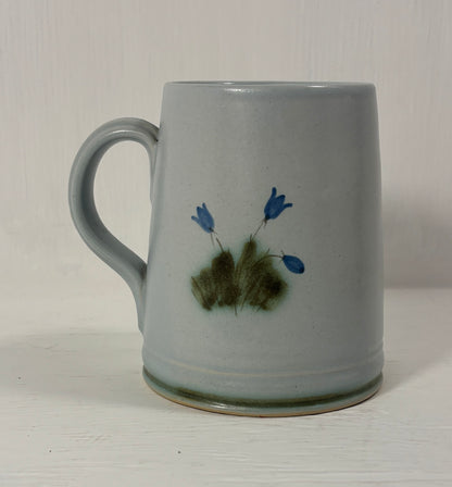 Ceramic mug with floral design on a plain background