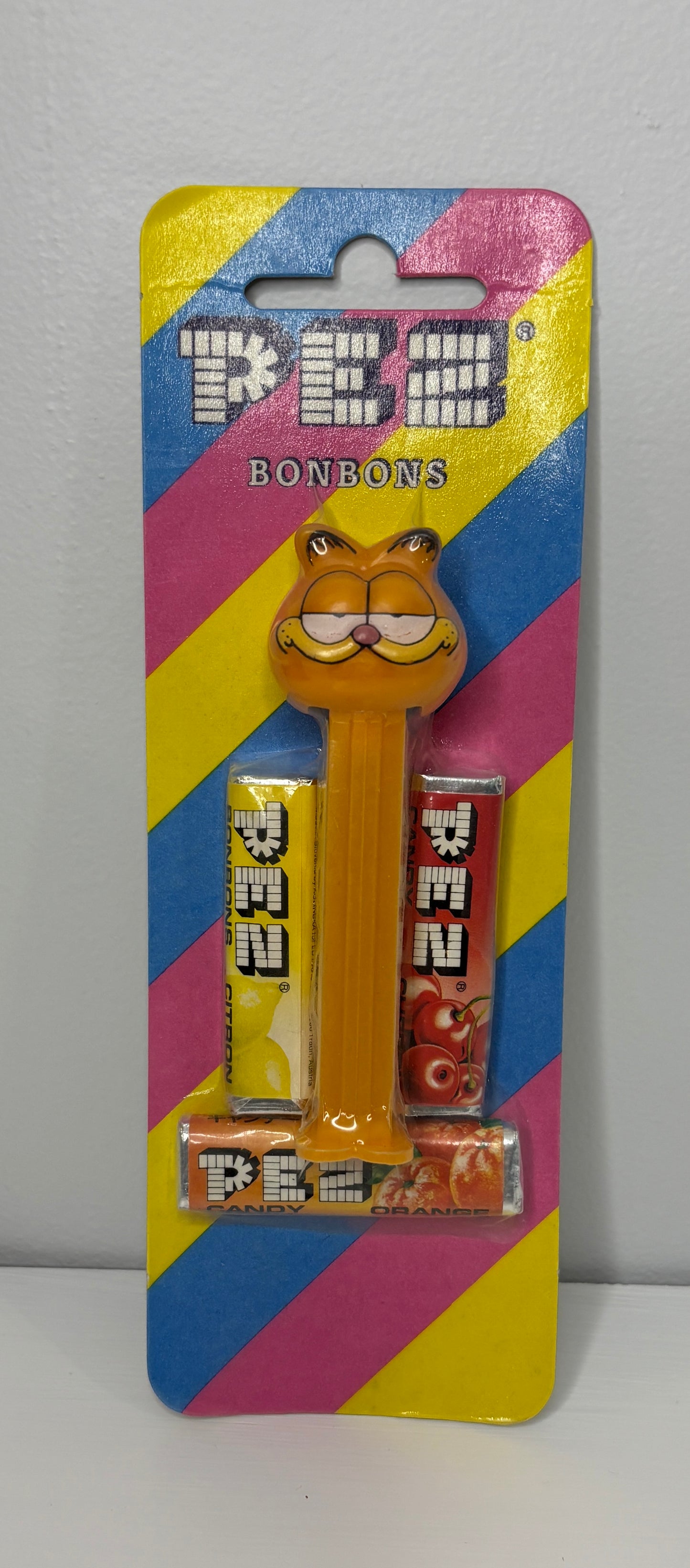 PEZ candy dispenser with colorful packaging featuring a cartoon character on a gray background