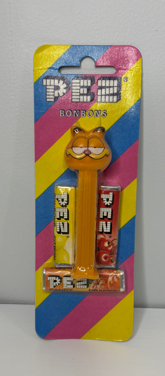 PEZ candy dispenser with colorful packaging featuring a cartoon character on a gray background