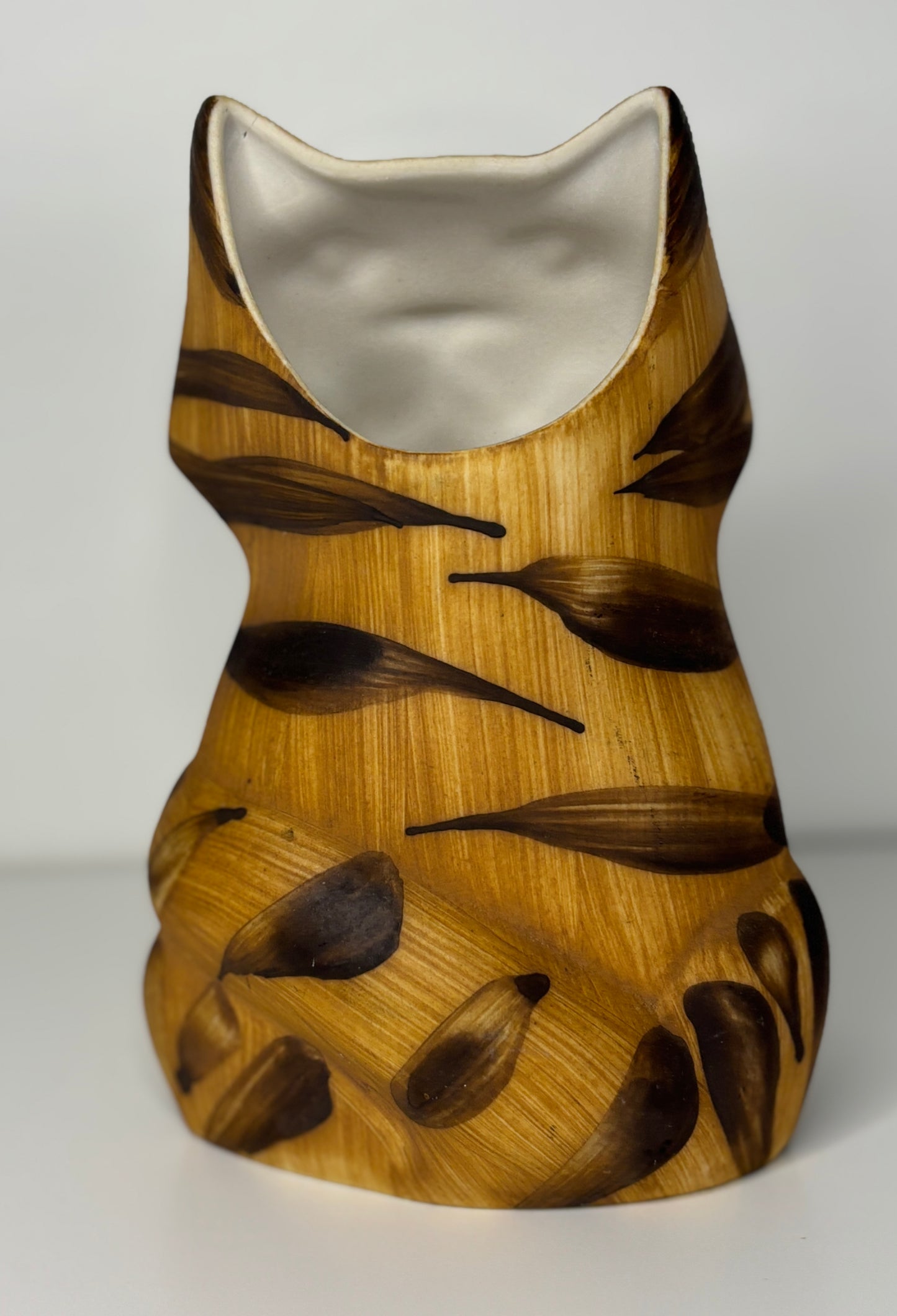 Wooden vase with leaf pattern on a white background