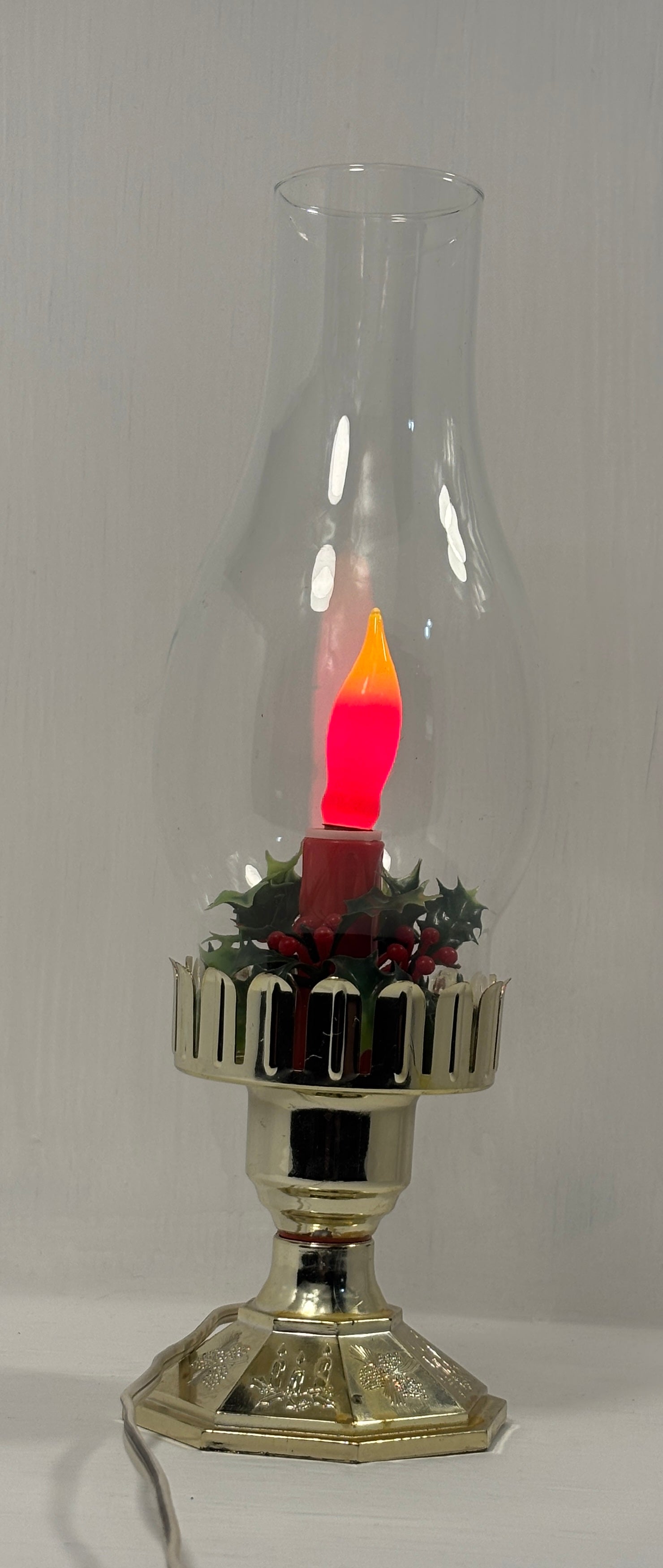 Decorative oil lamp with a red candle inside on a plain background