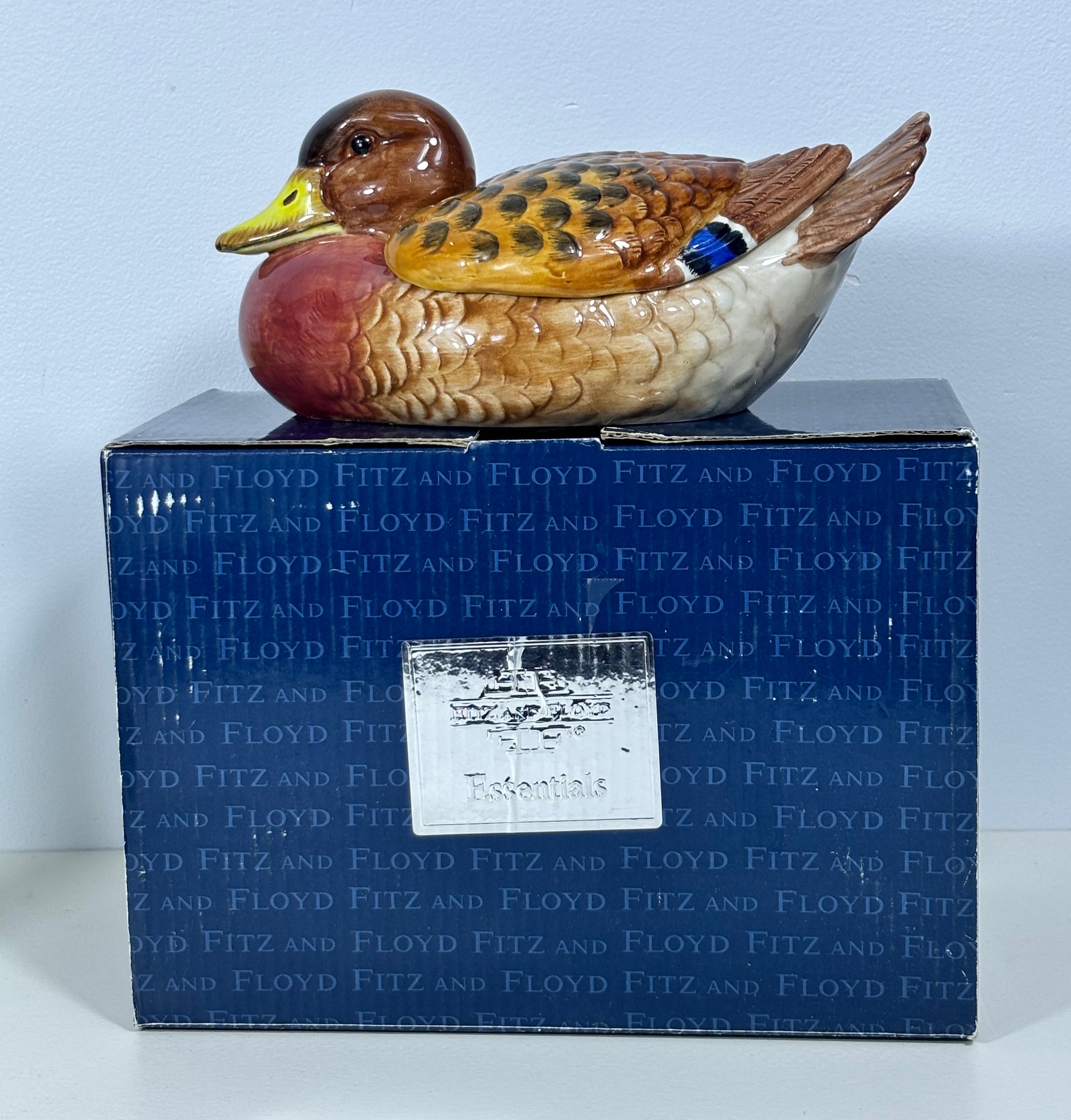 Colorful duck figurine on a blue box with 'Floyd Fitz' branding