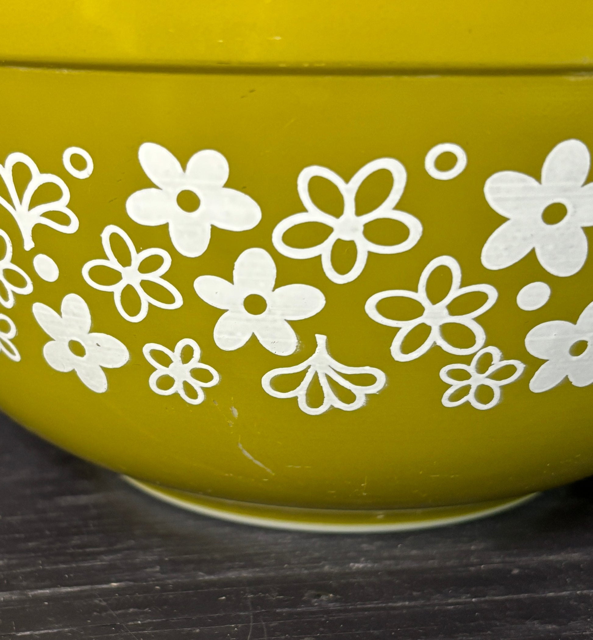 Green bowl with white floral patterns on a dark surface