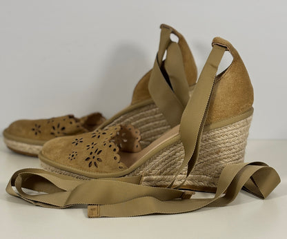 Pair of tan wedge sandals with espadrille soles on a white background