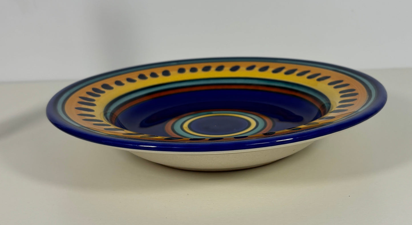 Ceramic bowl with blue and yellow decorative rim on a white background
