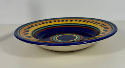Ceramic bowl with blue and yellow decorative rim on a white background