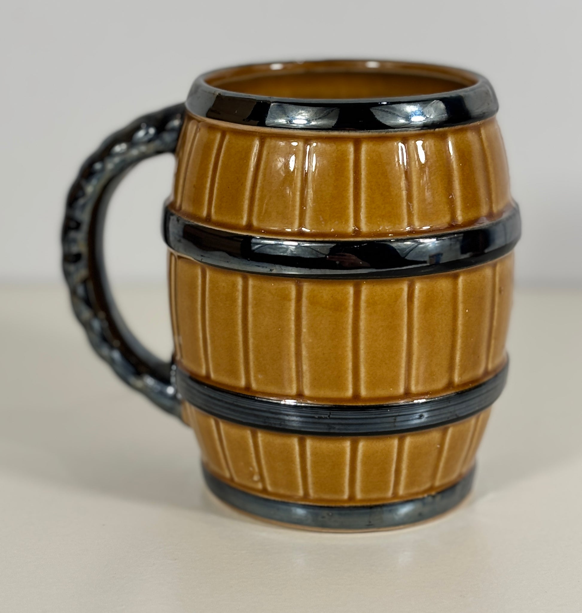 Barrel-shaped mug with black handle on a white background