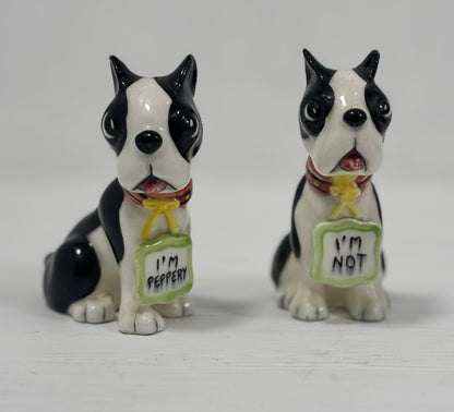 Two black and white dog figurines with 'I'm Pepper' and 'I'm Not' signs on a white background