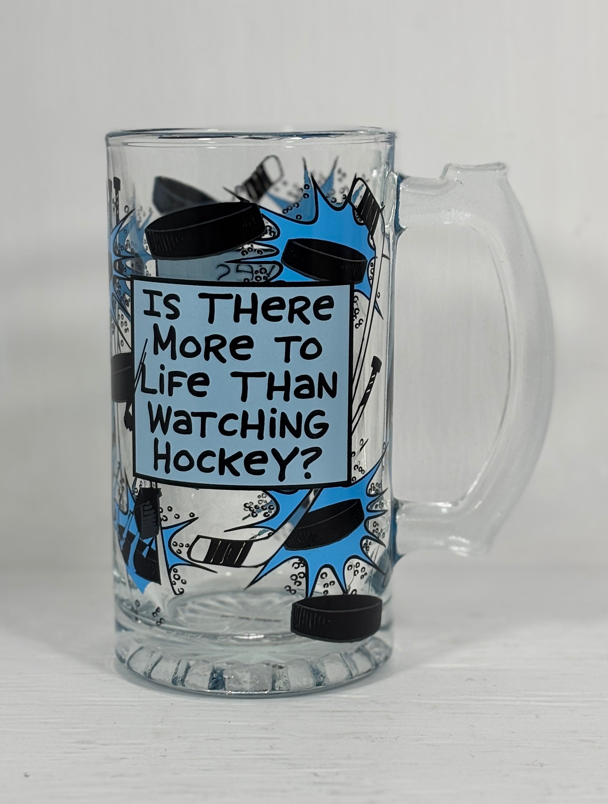 Glass mug with hockey-themed design and text on a white background
