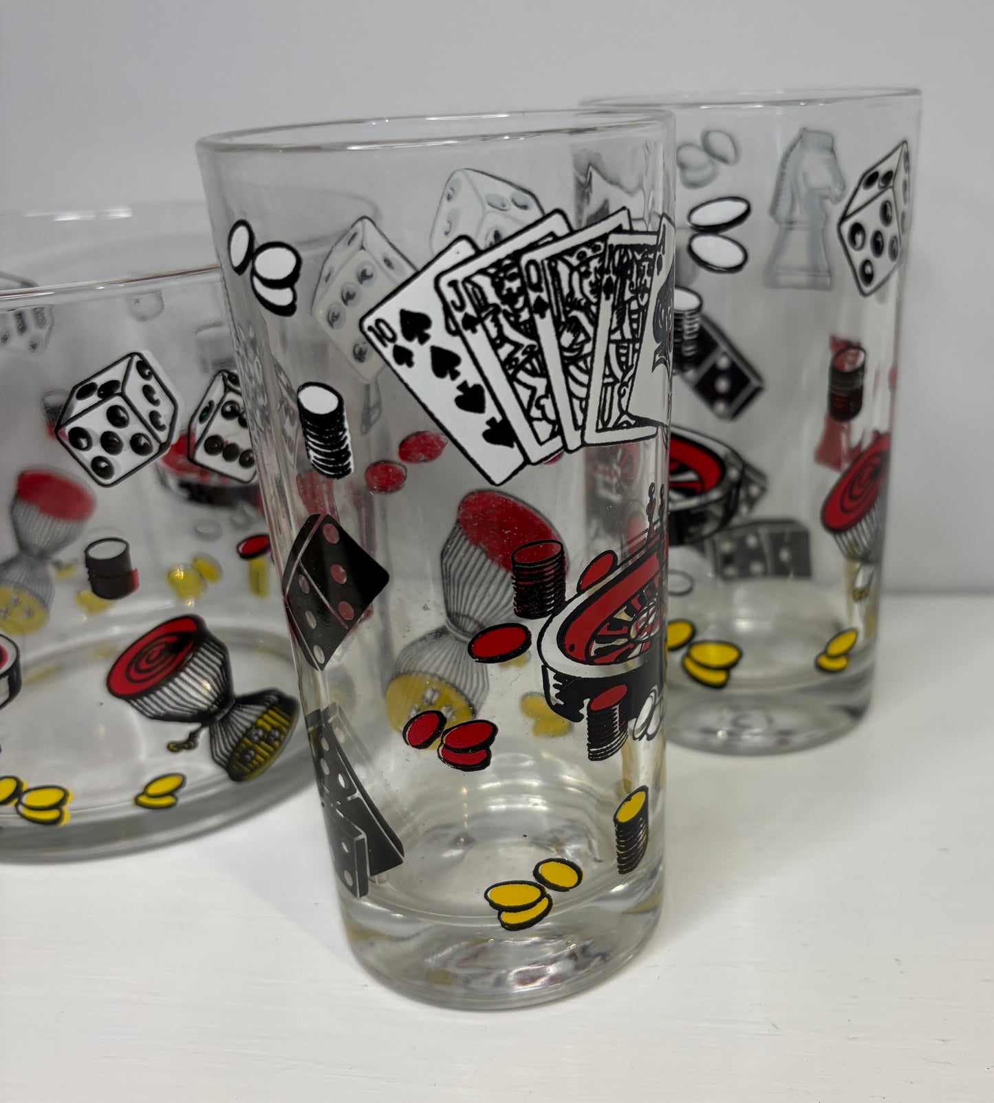 Two glass tumblers with poker-themed designs on a white background